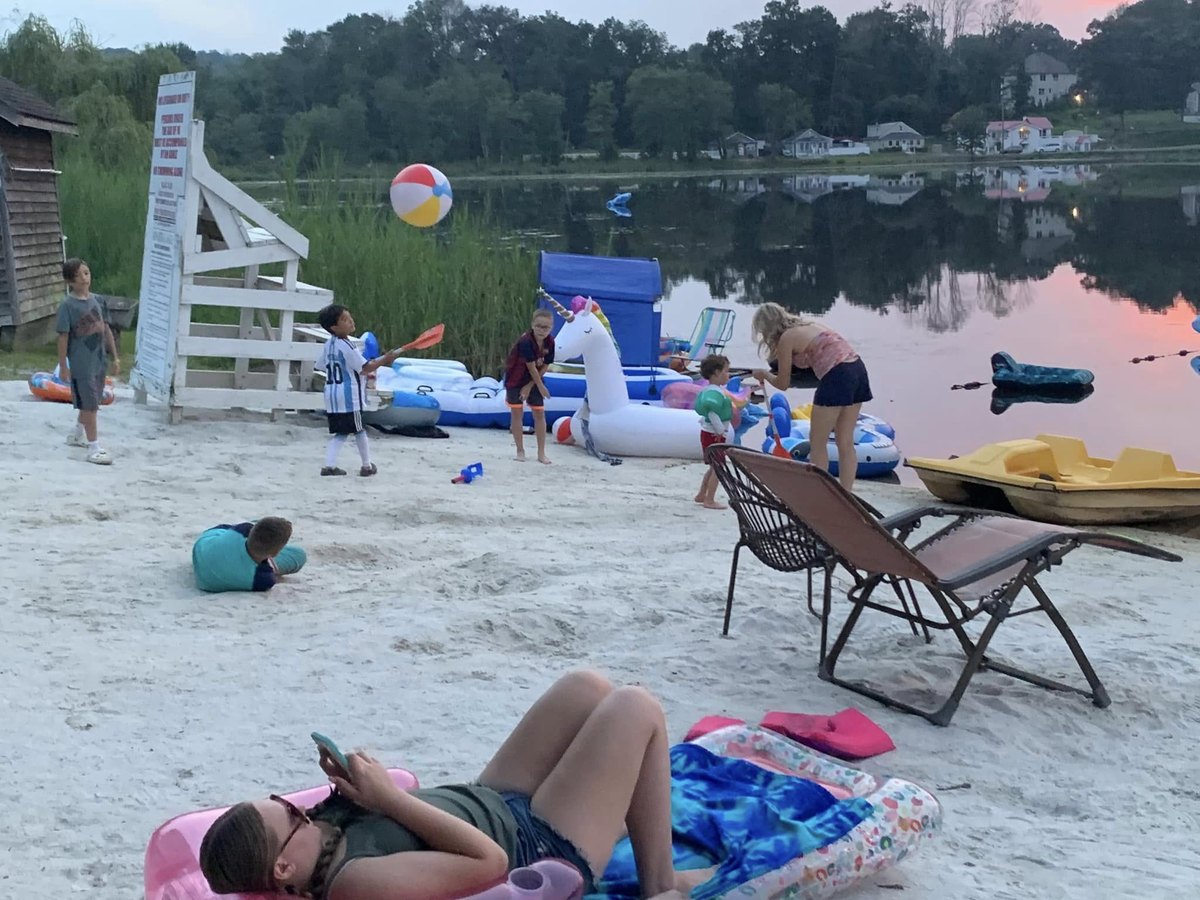 Families enjoying the Sparta Lake beach and water at dusk