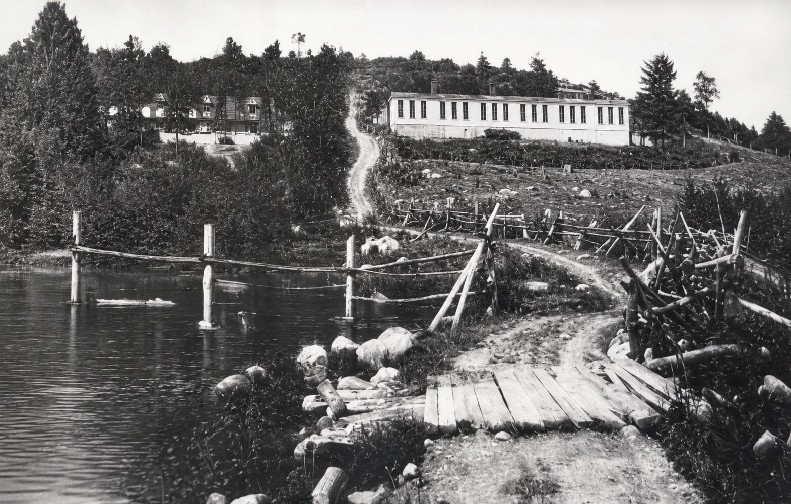 Historic view of early buildings and paths along Sparta Lake